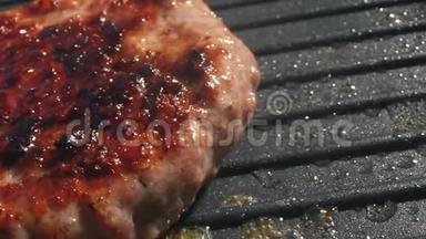 一个肥肥多汁的汉堡肉夹菜在烤架上准备好了，热和烟